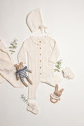 Little Box First Outfit da NOOK KIDS em tom cru, com conjunto de algodão orgânico e botinhas artesanais.
