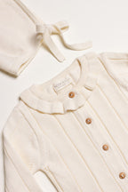 Little Box First Outfit da NOOK KIDS em tom cru, com conjunto de algodão orgânico e botinhas artesanais.