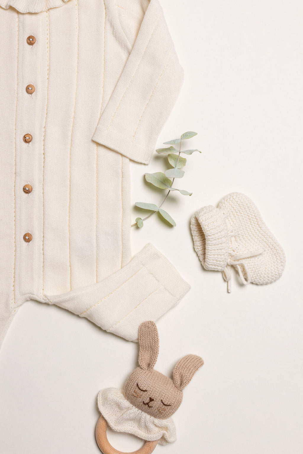 Little Box First Outfit da NOOK KIDS em tom cru, com conjunto de algodão orgânico e botinhas artesanais.