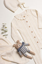 Little Box First Outfit da NOOK KIDS em tom cru, com conjunto de algodão orgânico e botinhas artesanais.