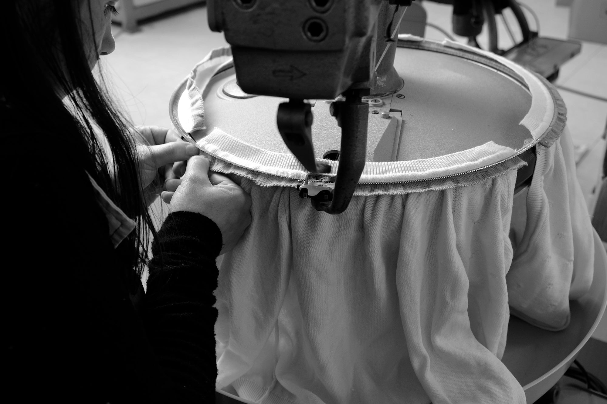 Costureira a trabalhar na unidade têxtil Madalena Beça em Portugal, garantindo a produção local e sustentável das peças em algodão orgânico da NOOK KIDS®.
